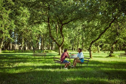 two people sitting at a table in a park at Agriturismo Lunadoro in Monticchiello