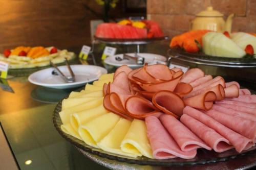 a tray of meats and cheese on a table at Terra dos Diamantes Hotel in Lençóis