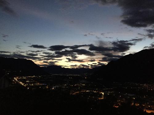 a view of a city at sunset with mountains at Appartamento Morobbia in Giubiasco