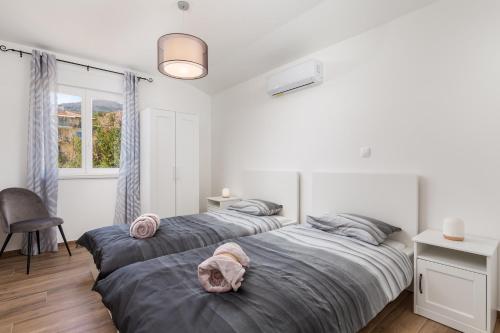 a bedroom with two beds and a desk and a window at Villa Ines in Ičići