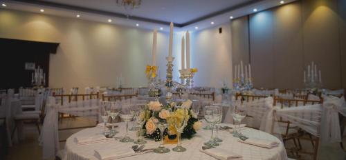 a room with white tables and chairs with glasses and flowers at Hotel CasaBlanca Cucuta in Cúcuta