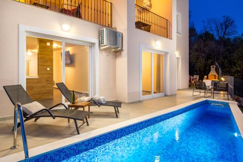 a house with a swimming pool and a patio at Villa Ines in Ičići