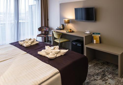 a hotel room with a bed and a desk at Hotel Golden Lake Resort in Balatonfüred