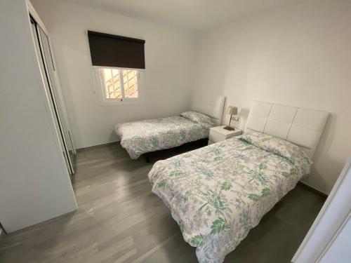 モロ・デル・ハブレにあるJandia Suiteのベッドルーム1室(ベッド2台、窓付)