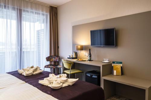 a hotel room with a bed and a desk at Hotel Golden Lake Resort in Balatonfüred