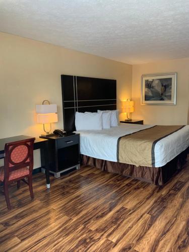 カータースビルにあるCountry Hearth Inn & Suites Cartersvilleの大きなベッドとデスクが備わるホテルルームです。