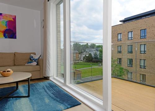 Chiswick的住宿－Executive Apartment Near Chiswick and Kew Gardens，客厅设有大窗户和沙发