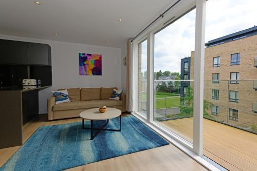 a living room with a couch and a large window at Executive Apartment Near Chiswick and Kew Gardens in Chiswick