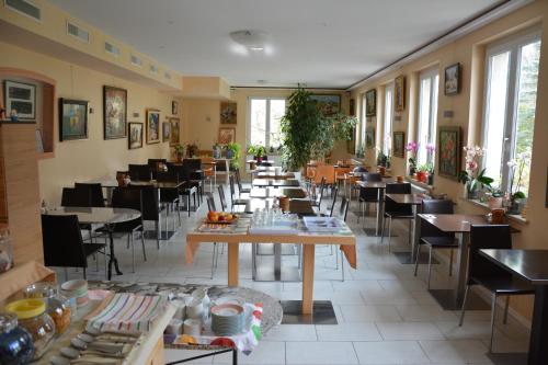 un comedor con mesas, sillas y ventanas en Hotel Hessengüetli, en Winterthur