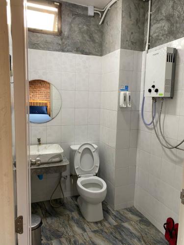 La salle de bains est pourvue de toilettes et d'un lavabo. dans l'établissement PilokMyhome ที่พักเหมืองปิล็อก บ้านอีต่อง, à Ban Pilok Khi