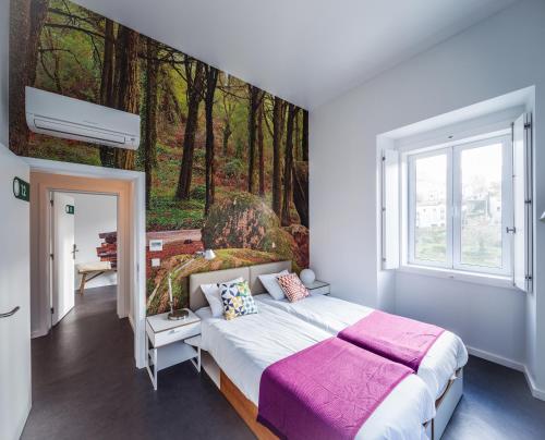 a bedroom with a bed with a painting of a forest at Moon Hill Hostel in Sintra