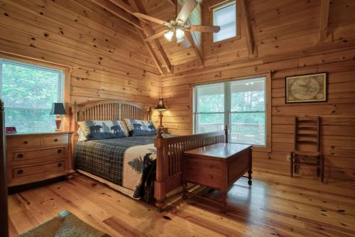 a bedroom with a bed and a desk and windows at Saluda Cabin Home Amazing Mountain Views Pets Ok in Saluda