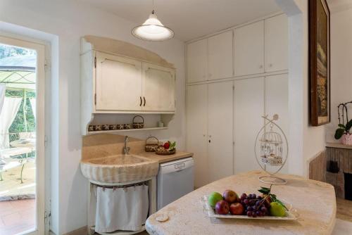 - une cuisine avec un évier et un bol de fruits sur un comptoir dans l'établissement Azalea, à Castagneto Carducci