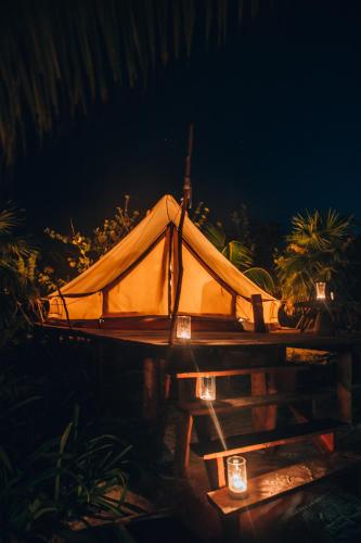 a tent is set up on a table at night at Glamp Ikal Tulum in Tulum