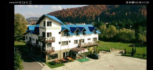 a large white building with a blue roof at HOTEL ALL TIMES in Timisul de Jos