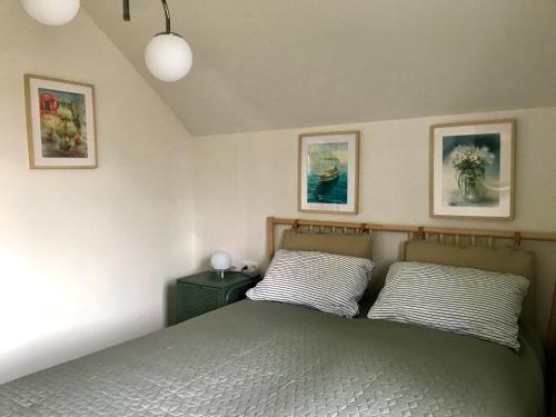 a bedroom with a bed and two pictures on the wall at Apartment Green Paradise in Moravske-Toplice