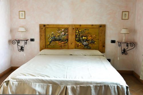 a bedroom with a bed with a painting on the wall at La Fonte Carducciana in San Casciano dei Bagni