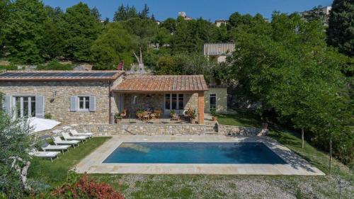 an external view of a stone house with a swimming pool at La Casa di Radda in Radda in Chianti