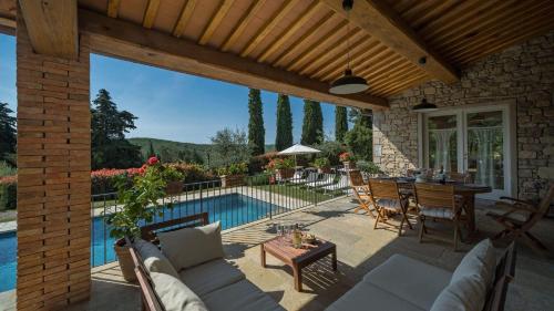 a patio with a pool and a table and chairs at La Casa di Radda in Radda in Chianti