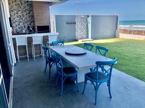 - une table et des chaises sur une terrasse donnant sur l'océan dans l'établissement Tabubinha Paradise, à Beberibe
