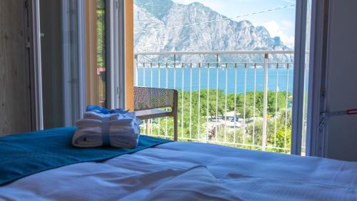a bedroom with a bed and a view of the ocean at Hotel Casa Marinella in Malcesine