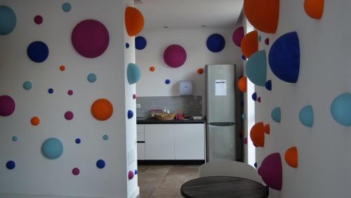 a kitchen with a wall covered in colorful circles at Club Esse Roccaruja in Stintino
