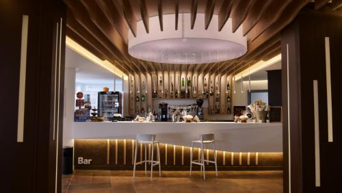 a kitchen with a bar with stools in a room at Club Esse Roccaruja in Stintino