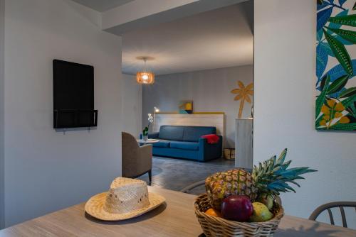 a living room with a table with a bowl of fruit at Le Domaine du Golf*** by Ateya Vacances in Fabrègues