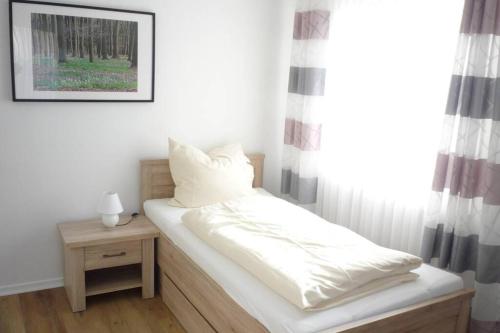 Bett in einem Zimmer mit einem Fenster und einem Tisch in der Unterkunft Schlafen vor den Toren von Osnabrück für 5 Pers. 