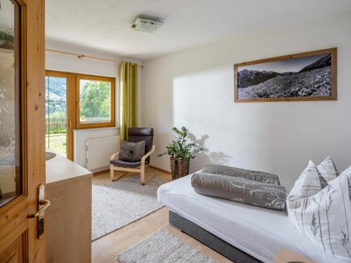 1 dormitorio con 1 cama, 1 silla y 1 ventana en Haus Ausblick en Wenns
