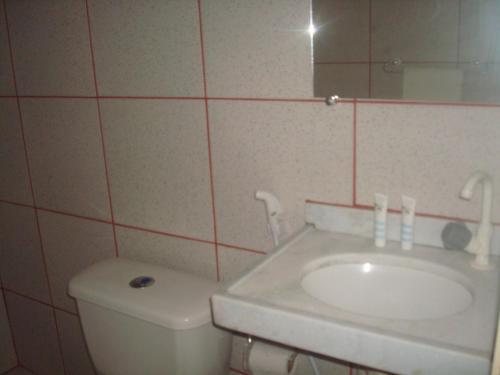 een badkamer met een wastafel, een toilet en een spiegel bij Sol da Barra in Barra Nova