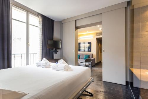um quarto com uma cama grande e toalhas brancas em CMG Suite Deluxe- 44 em Paris