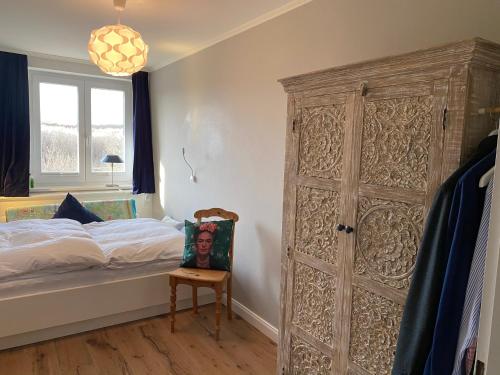 1 dormitorio con 1 cama y puerta de madera grande en Kliffssand 33, en Kampen
