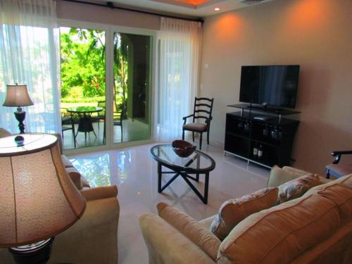 a living room with a couch and a flat screen tv at Tamarindo Condo 206 Matapalo in Tamarindo