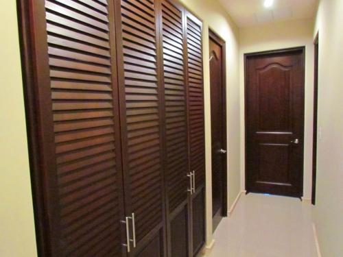 a walk in closet with wooden doors and a hallway at Tamarindo Condo 206 Matapalo in Tamarindo