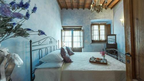 Un dormitorio con una cama en una habitación azul. en Poggio alle Fonti 11, en Montevarchi