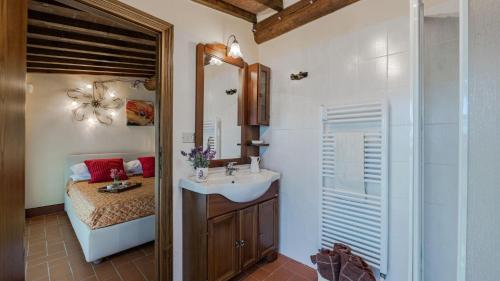 Un baño con lavabo, espejo y ducha. en Poggio alle Fonti 11, en Montevarchi