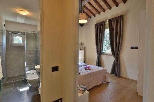 Un dormitorio con una cama y un baño. en Villa La Torre 16, en Montespertoli