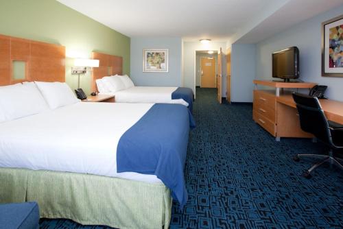 a hotel room with two beds and a desk and a television at Holiday Inn Express Hotel & Suites Rock Springs Green River by IHG in Rock Springs