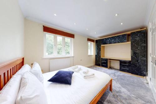 a bedroom with a large white bed and a fireplace at Super 2 bed House wPrivateParking&PrivateGarden in London