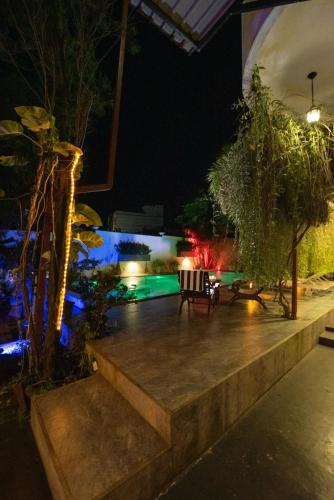 a garden at night with a bench and lights at Avon Villa in Hikkaduwa