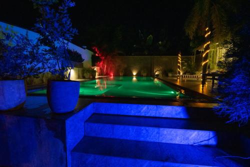 a swimming pool lit up at night with blue lights at Avon Villa in Hikkaduwa