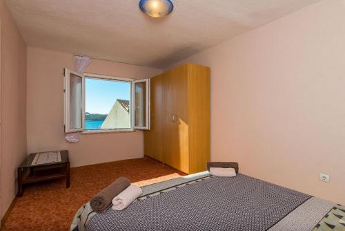 ein Schlafzimmer mit einem Bett und einem Fenster in der Unterkunft Apartment Angelina in Dubrovnik