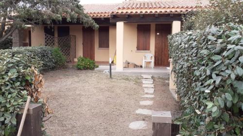 a house with a fence and a chair in the yard at Villetta Reparata in Santa Teresa Gallura