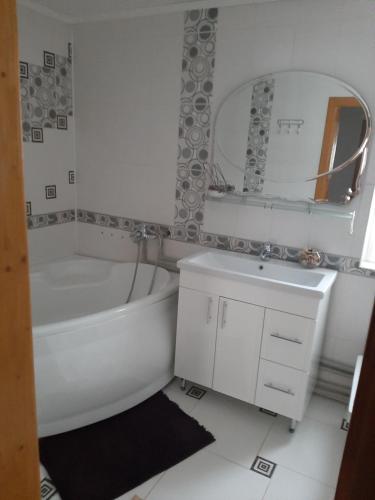 a bathroom with a tub and a sink and a mirror at У Ані in Lazeshchyna