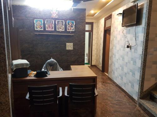 a kitchen with a counter and two chairs in a room at K K RENUKA DHARAMSHALA in Haridwār