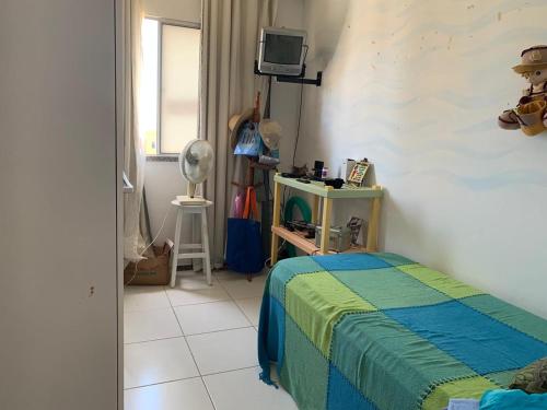 a bedroom with a bed and a television in it at Apartamento Aruana a 3 Km da praia in Atalaia Velha
