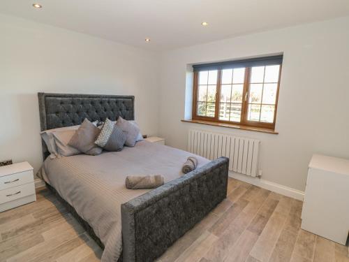 ein Schlafzimmer mit einem großen Bett und einem Fenster in der Unterkunft Afon Rhos Bach in Caernarfon