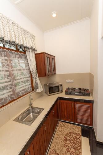 a kitchen with a sink and a microwave at Avon Villa in Hikkaduwa