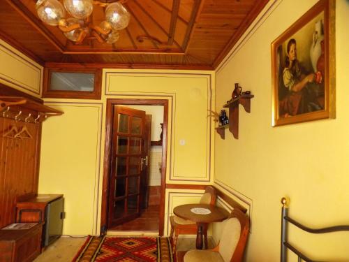 a room with a table and a picture on the wall at Dona Guest House - Horse Riding in Koprivshtitsa